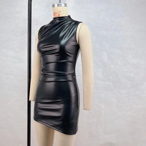 Détail de la robe en similicuir noir montrant les plis et l'ourlet irrégulier
