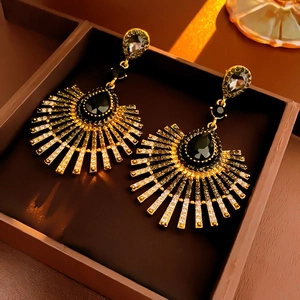 Close-up of vintage teardrop crystal fan earrings in black and gold jewelry box