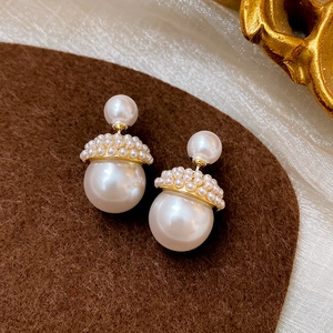 Détail macro de boucles d'oreilles perles en forme de gland avec calotte dorée et style rétro