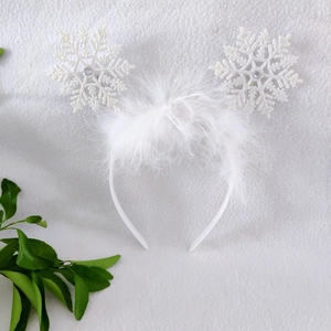 Detail of white snowflake headband with glitter accents and soft white feathers