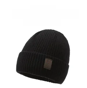 Detailed view of black knitted beanie with a premium leather patch and ribbed texture