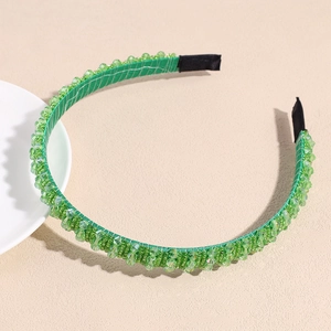 Detail of green beaded headband with faceted crystals and satin fabric wrapping