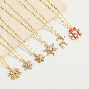 Golden Christmas necklaces featuring snowflakes, reindeer, and gift pendants with pearls