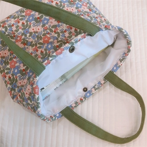 Floral canvas lunch bag detail showing green handles and silver magnetic closure