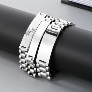 Detailed close-up of three men's stainless steel curb chain bracelets on a black display