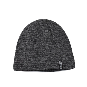 Macro detail of dark grey knit beanie featuring fine waffle texture and branded woven label