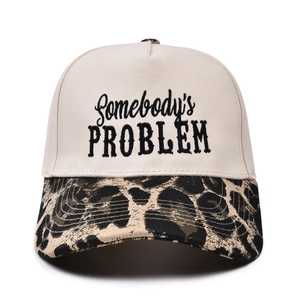 Detailed view of the leopard print brim and Somebody's Problem embroidery on a trucker hat
