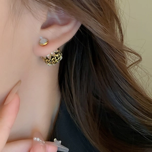 Gros plan de boucles d'oreilles pendantes en chaîne dorée avec pierres précieuses