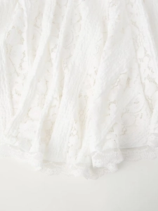 Gros plan sur le tissu en dentelle florale blanche et la texture plissée de la robe