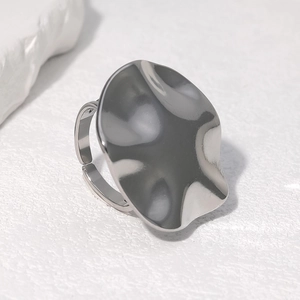 Macro top view of silver irregular fluid wave ring with brushed metallic texture details