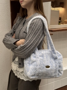 Détail d'un sac à main en peluche bleu clair à motif marbré porté par un mannequin