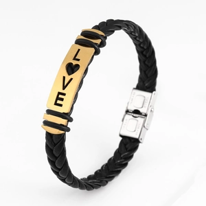 Close-up of leather braided bracelet with gold plate featuring LOVE and heart cutout