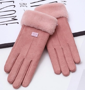 Close-up of pink faux suede winter gloves with fluffy fur cuffs and leather fashion label