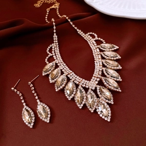 Detailed view of luxury champagne gold water drop jewelry set on red velvet fabric