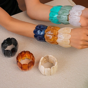 Detail of wide acrylic bangles with marble and tortoiseshell patterns in various colors