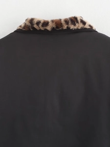 Close-up of the back of a black bomber jacket featuring a stylish leopard faux fur collar
