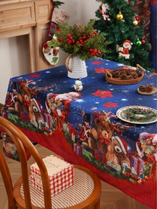 Close-up of festive Christmas tablecloth with Teddy Bear and Santa Claus patterns