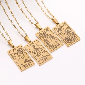Detailed macro view of gold tarot card necklaces: The Fool, Justice, Emperor, and Lovers