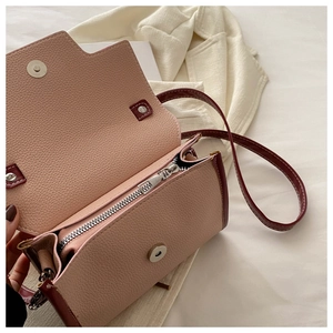 Detail view of pink lychee leather crossbody bag interior with zipper pocket and magnetic closure