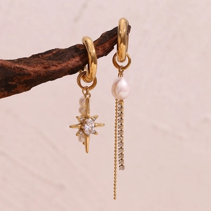Asymmetric gold star earrings with freshwater pearls and tassels on wood branch