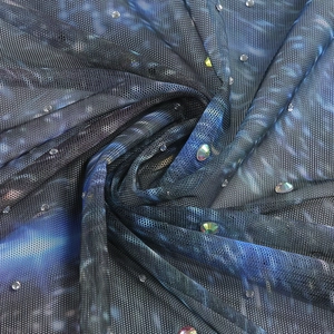Détail du tissu en maille imprimé galaxie avec des strass étincelants et un dégradé de bleu