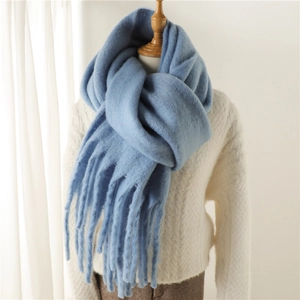 Gros plan détaillé sur une écharpe en mohair bleu clair avec de larges franges douces