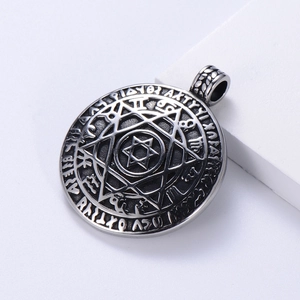 Macro detail of antique silver zodiac pendant with engraved star of David and runes