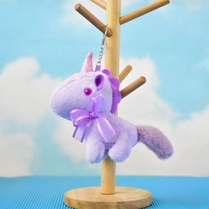 Lila Plüsch-Einhorn-Schlüsselanhänger mit Satinschleife an einem Holzständer