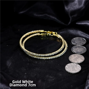 Detail shot of 7cm oversized gold tone hoop earrings with pavé rhinestones on black silk