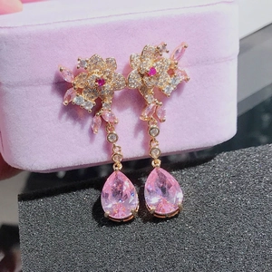 Detailed macro view of pink pear-shaped gemstone earrings with floral cluster setting