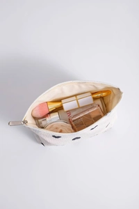 Detailed view of white heart-embroidered makeup bag showing interior storage capacity