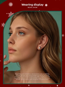 Detail view of a Christmas pearl earring with a red Santa hat worn by a female model