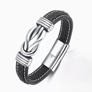 Detailed view of men's black braided leather bracelet with silver clasp and gift card