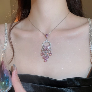 Detail of silver necklace featuring pink zircon butterfly pendant and dangling tassels