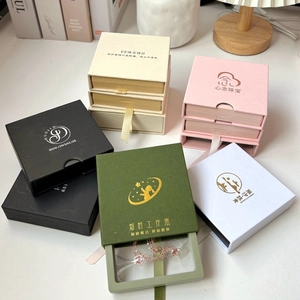 Detalle macro de cajas de regalo para joyas multicolores con logotipo de pan de oro