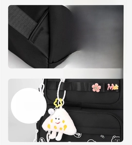 Detail of durable black nylon school bag featuring cartoon bear prints and cute charms