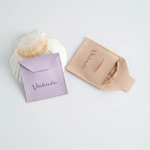 Detalle de bolsas de joyería de microfibra en violeta y beige de ante suave