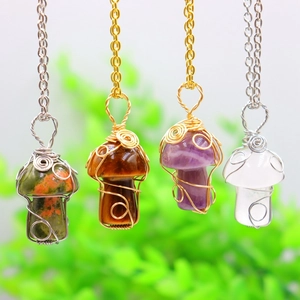 Natural crystal mushroom pendant necklace with handmade wire wrapping on a garden background