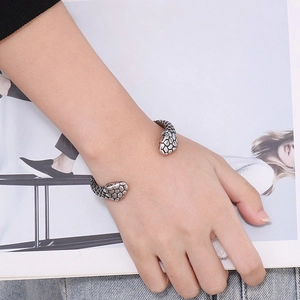 Close-up of vintage punk snake head open bracelet with detailed silver scale texture