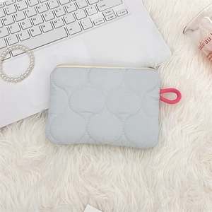Close-up of a light blue quilted cosmetic bag with cloud pattern on soft plush fabric