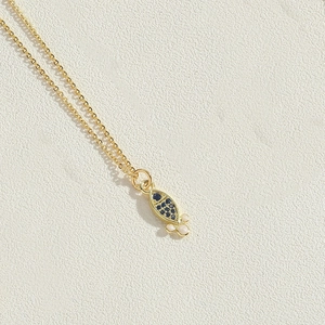 Detailed close-up of 14K gold plated dolphin pendant with blue zircons and white pearls