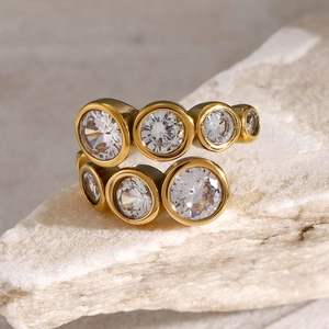 Close-up of 18k gold plated stainless steel ring with zircon stones on stone background