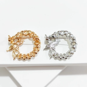 Detailed back view of round hollow brooch showing silver and gold safety pin clasp mechanism