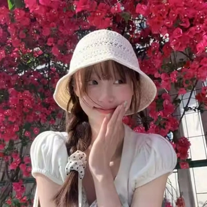 Close-up of white crochet bucket hat with hollow knit pattern and wavy brim