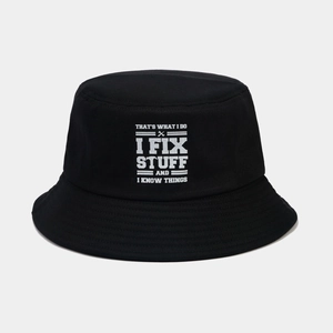 Détail du chapeau bob noir avec slogan blanc imprimé et texture en coton de haute qualité