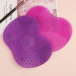 Close-up of heart-shaped silicone makeup brush cleaning mats with diverse textures