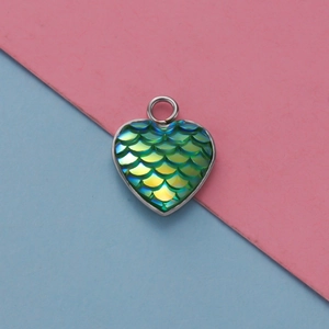 Dettaglio del ciondolo a forma di cuore con scaglie di sirena verdi e cornice in argento