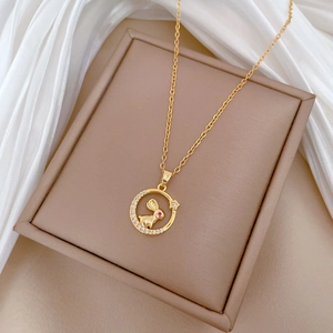 Macro shot of gold rabbit necklace with red gem eyes and sparkling zircon pendant
