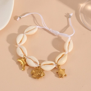 Detail of woven shell bracelet with golden dolphin, tropical fish and turtle charms