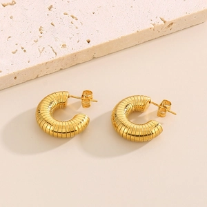 Boucles d'oreilles créoles C en acier inoxydable doré à texture striée sur fond de pierre